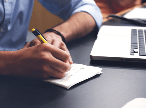 Jeune homme qui prend des notes sur du papier