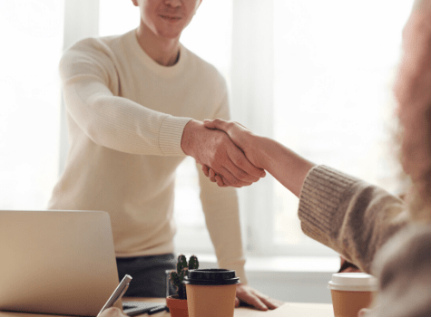 Jeune homme qui serre la main à un dirigeant d'entreprise