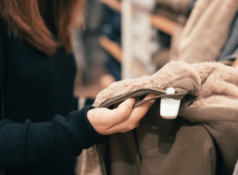 Vendeuse qui range des produits textiles dans un rayon